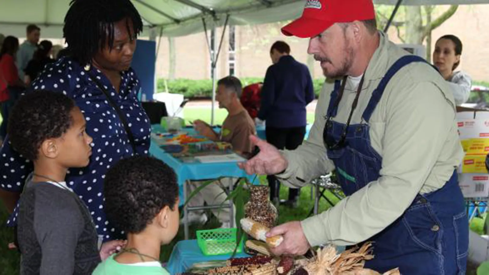 Dr. Hollick showing corn at WestFest to a family