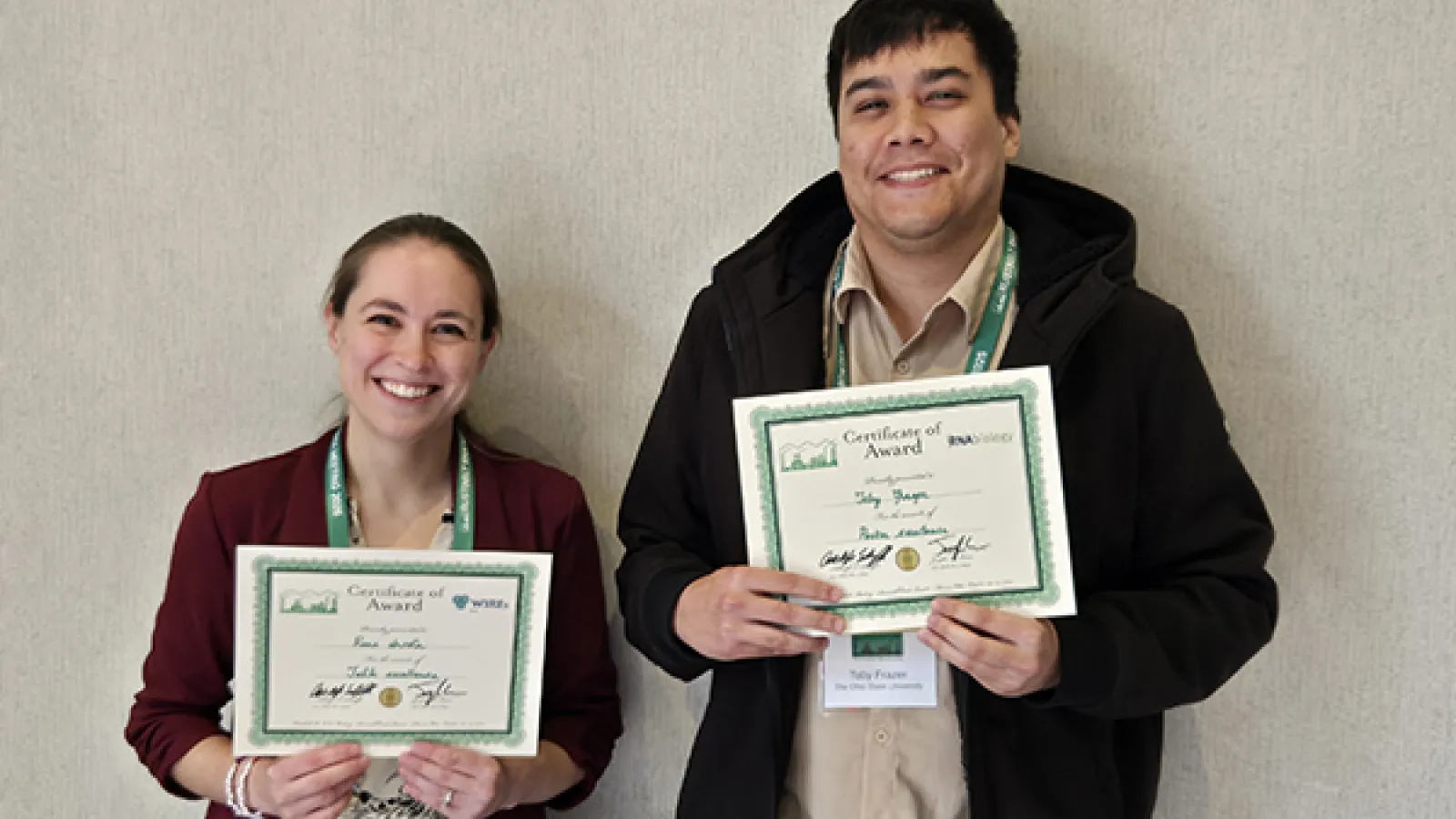 Rene Arvola and Toby Frazer smiling and holding their awards