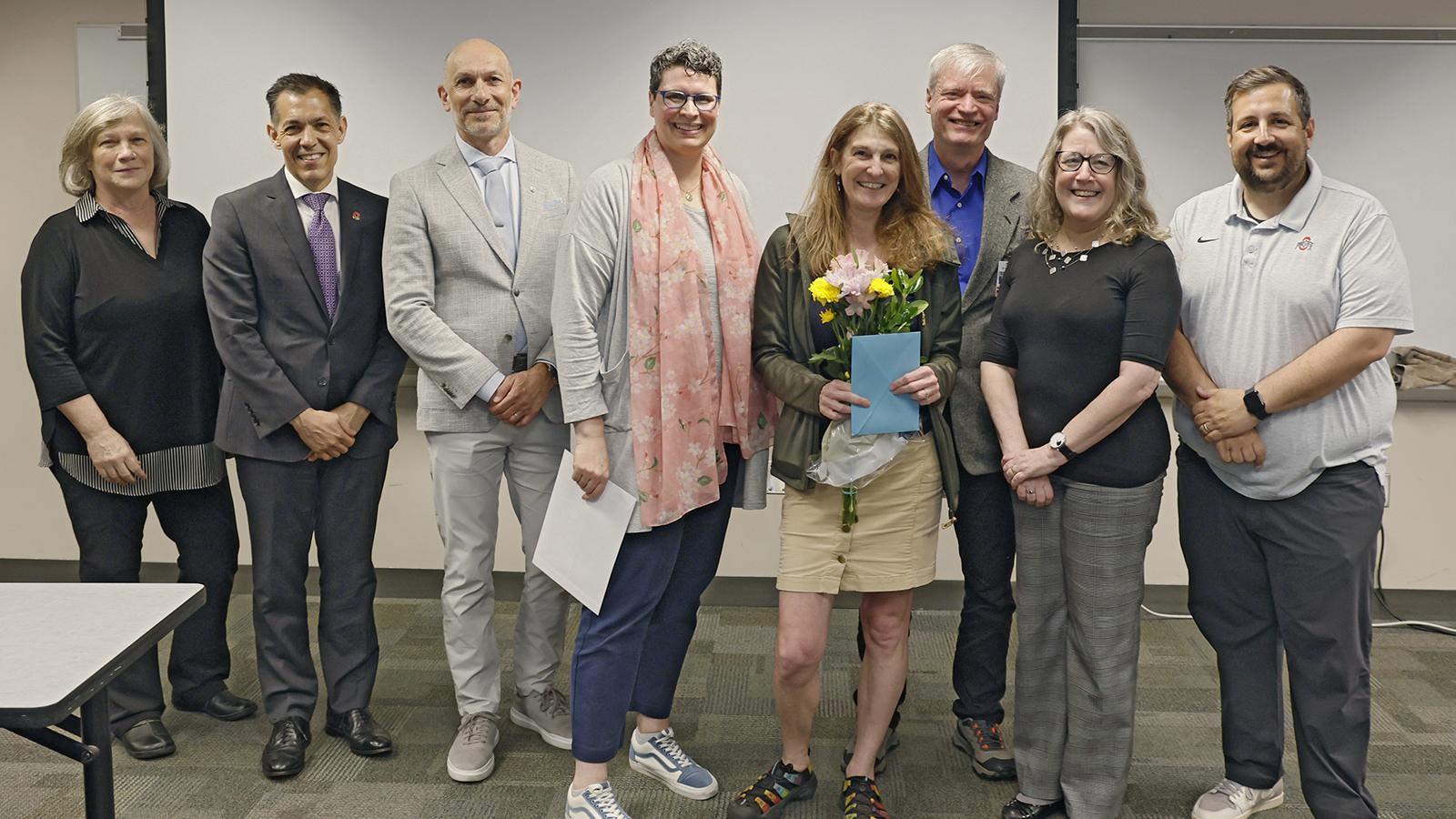Amanda surrounded by the people who came to surprise her with the award