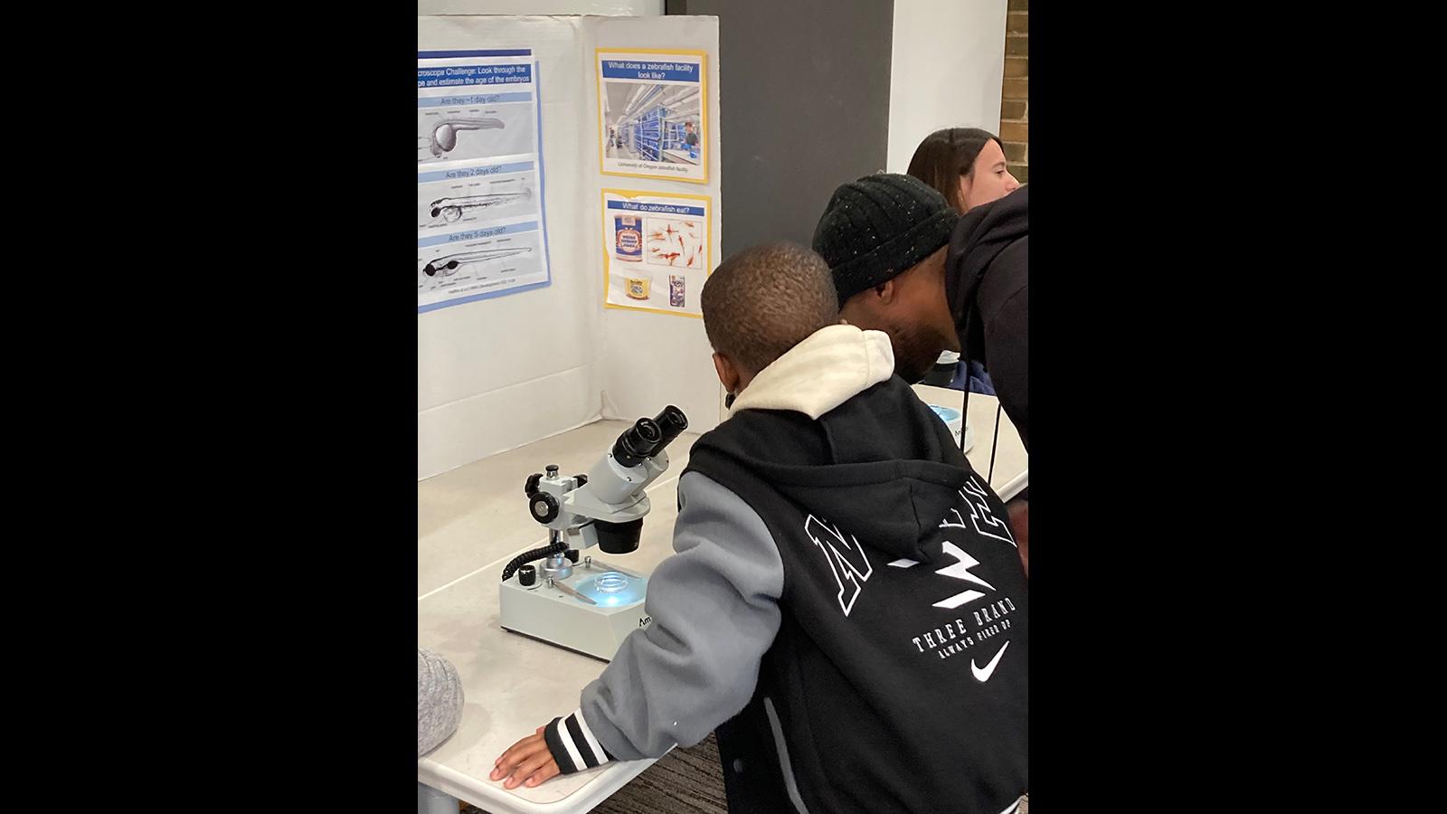 Two guests looking through microscopes